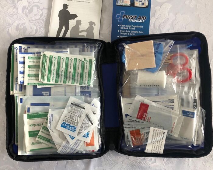 First aid essentials kit with bandages, antiseptic wipes, and scissors as adulting starter pack must-have for first apartment safety.