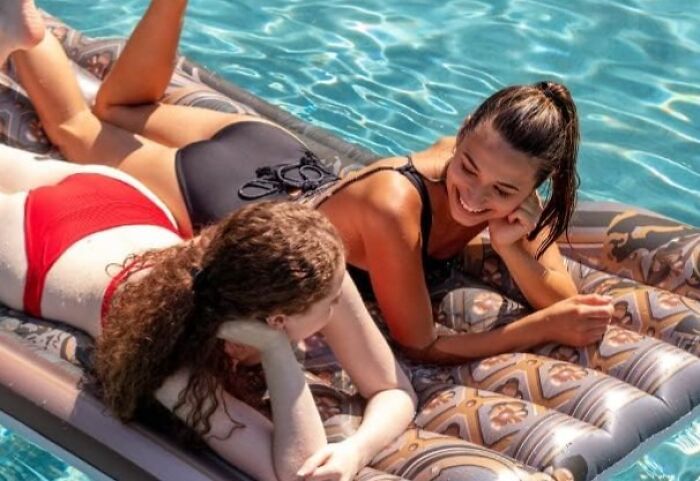 Two women in swimsuits relaxing on an inflatable float in a pool, illustrating bizarre finds affecting bank accounts.