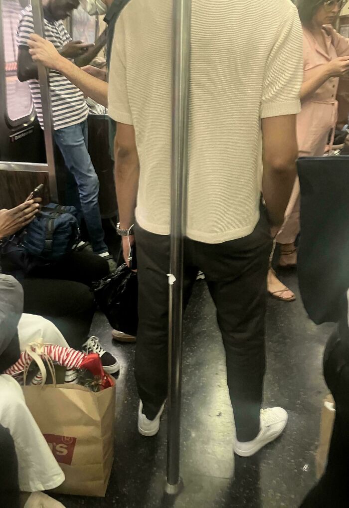 Crowded public transport passengers standing and sitting close together during a busy commute inside a subway car.