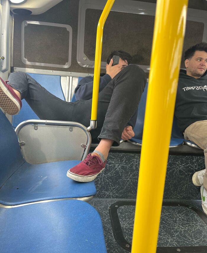 Public transport passengers sitting with feet on seats, showing rude and infuriating behavior on a bus.