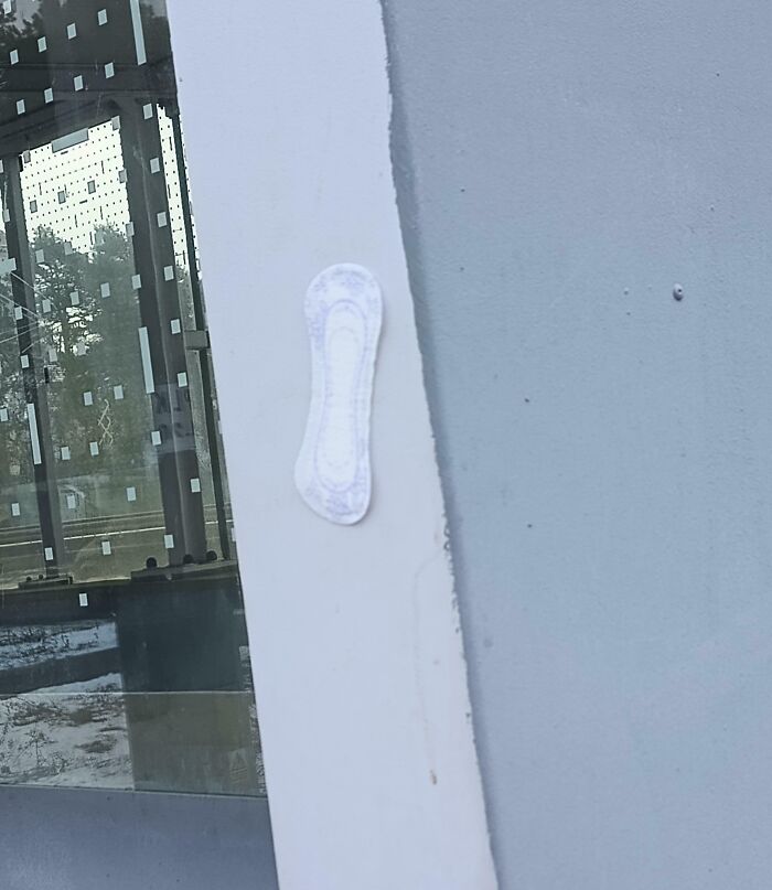 Sanitary pad stuck on a public transport window frame, highlighting infuriating passenger behavior in shared transit spaces.