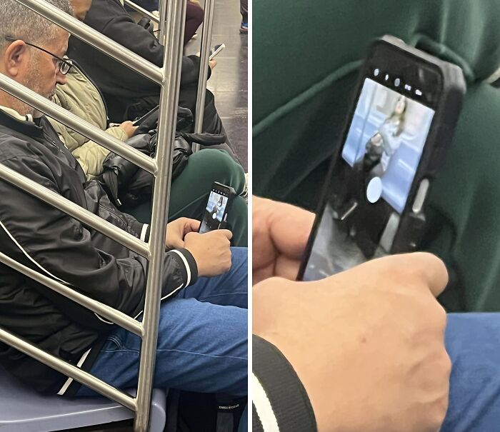 Man on public transport secretly taking a photo of a woman reflected on his phone screen while sitting next to a metal railing.