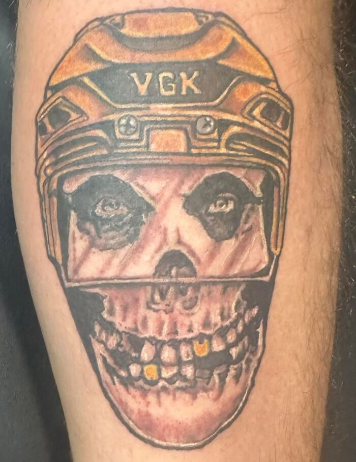 Bad tattoo of a skull wearing a VGK hockey helmet with distorted features and uneven coloring on a person's arm.