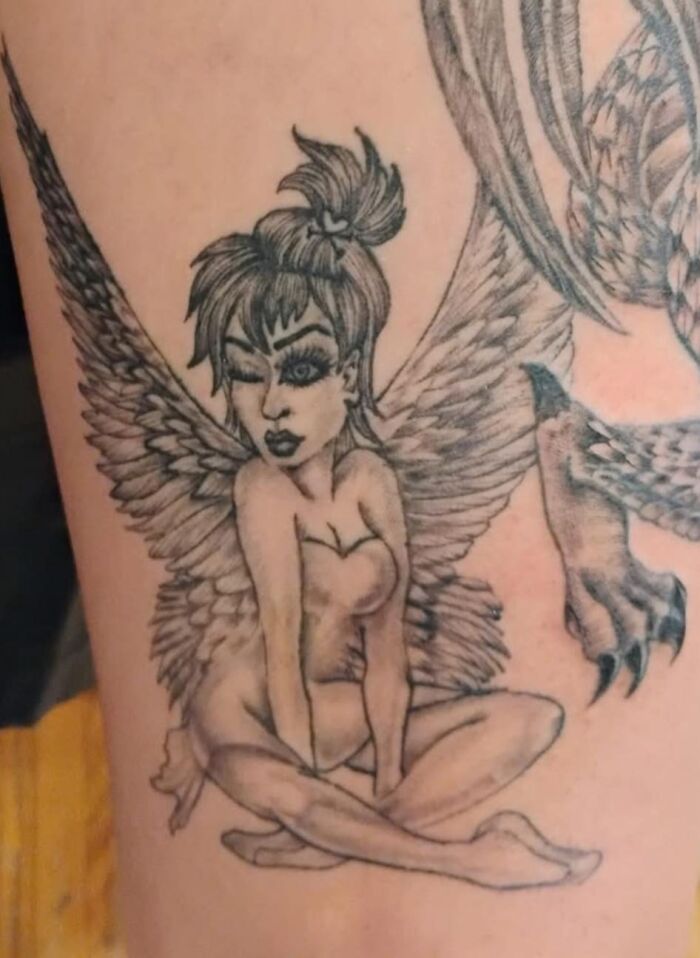 Tattoo of a winking fairy with exaggerated facial features and poorly executed shading, a hilariously bad inkshaming example.