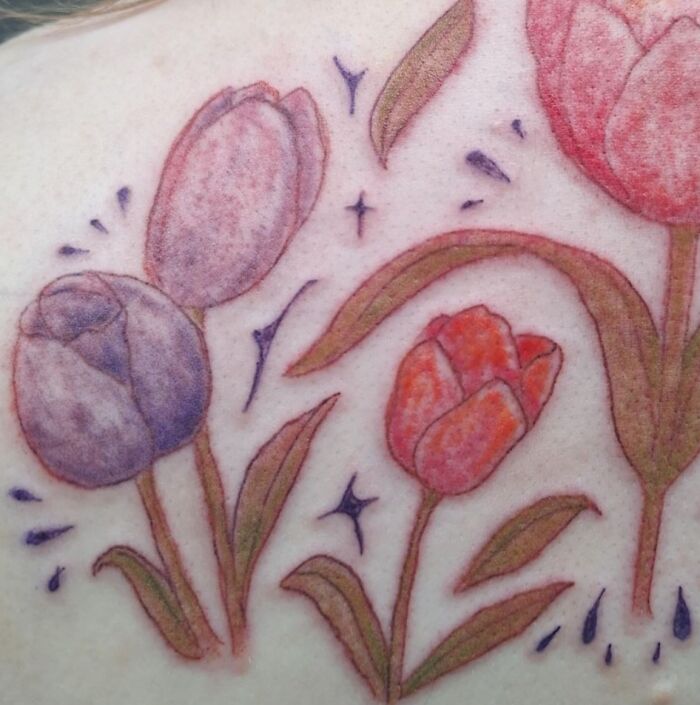 Tattoo of poorly shaded tulip flowers with uneven colors and lines, an example of hilariously bad tattoos and inkshaming.