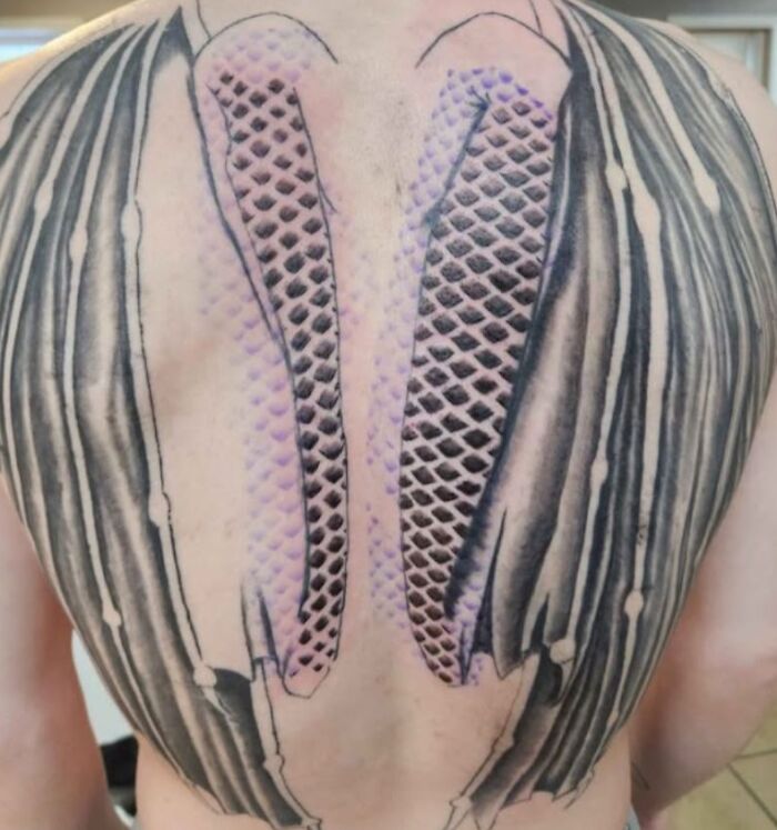 Back tattoo with a failed 3D design and bad tattoo art that looks unintentionally humorous.