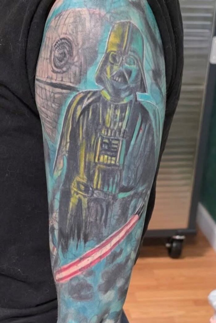 Tattoo sleeve featuring a poorly drawn Darth Vader and Death Star in a hilariously bad tattoo style.