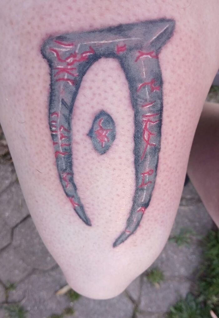 Tattoo on leg with unusual design featuring gray and red ink, illustrating a hilariously bad tattoo from inkshaming collection.