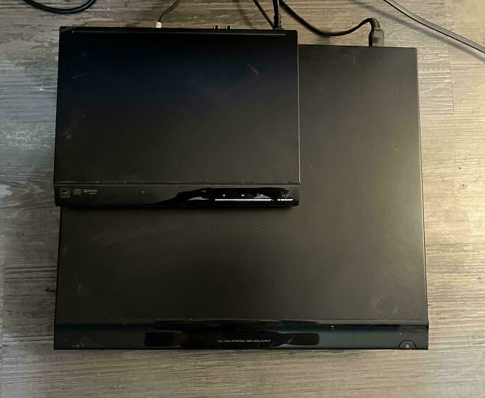 Black electronic devices placed on a wooden floor showing size comparison in fascinating comparison pics.