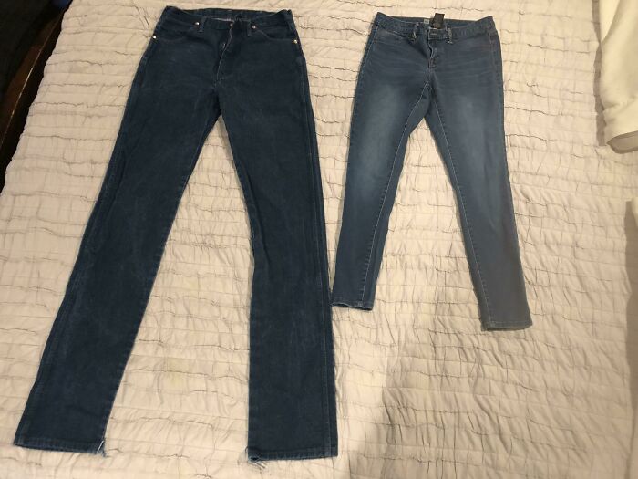 Two pairs of jeans in different shades of blue laid out side by side for comparison, highlighting variety in style.