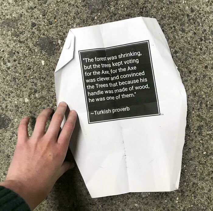 Hand holding a worn paper with a Turkish proverb, one of the historical mementos people randomly found on the ground.