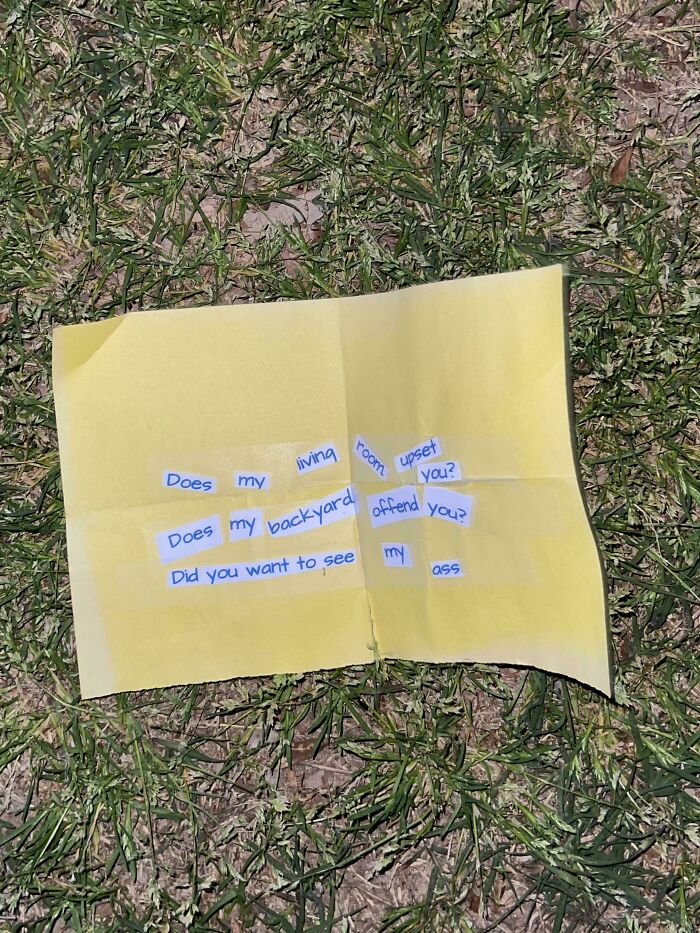 Yellow folded paper with cut-out words placed on grass, a quirky historical memento people randomly found outdoors.