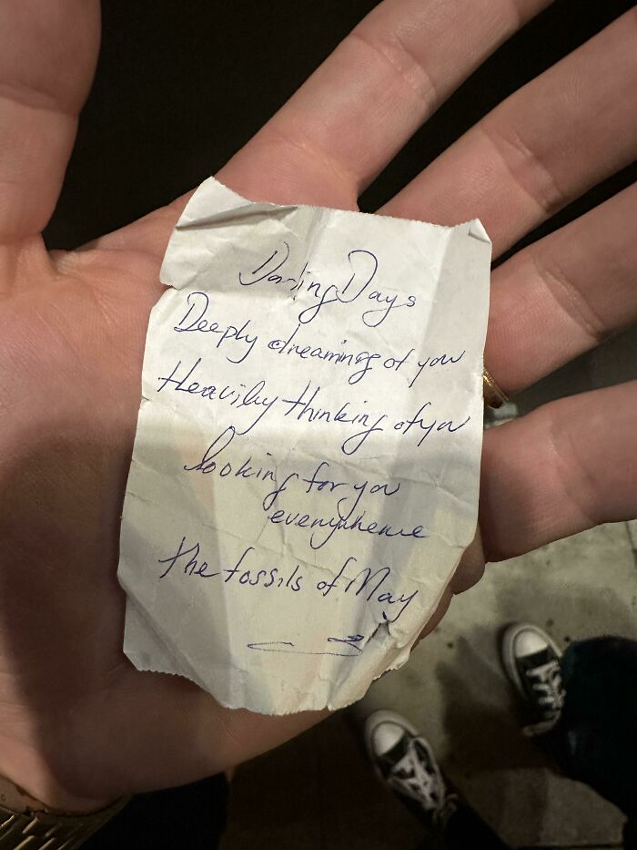 Hand holding a handwritten note with a poem, one of the historical mementos people randomly found.