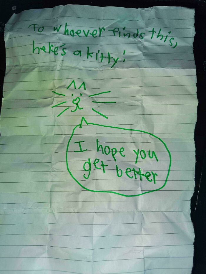 Handwritten note on lined paper with a drawn cat, offering kindness as a historical memento people randomly found.