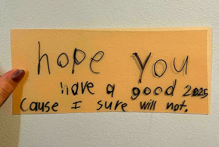 Handwritten note on yellow paper found as a historical memento expressing a sarcastic New Year wish for 2025.