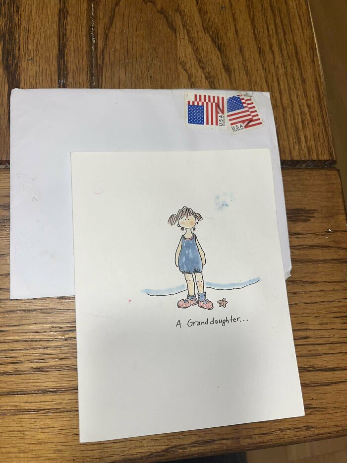 Hand-drawn granddaughter card with vintage postage stamps on a wooden table, a historical memento found randomly.