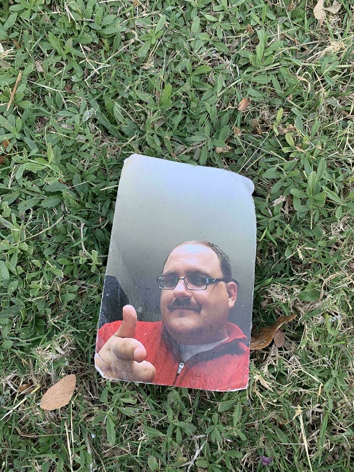 Worn photo of a man in a red jacket lying on grass, one of the historical mementos people randomly found.