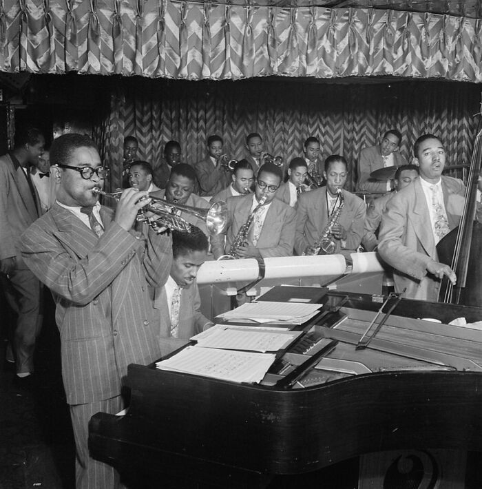 Jazz musicians playing instruments in a lively band capturing a crucial moment of the Harlem Renaissance era.