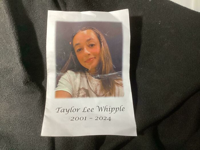 Printed memorial photo found among historical mementos showing a young woman dated 2001 to 2024 on fabric background