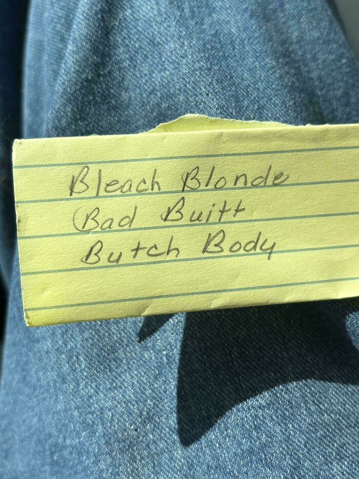 Yellow lined paper with handwritten words found among historical mementos, resting on blue denim fabric background.