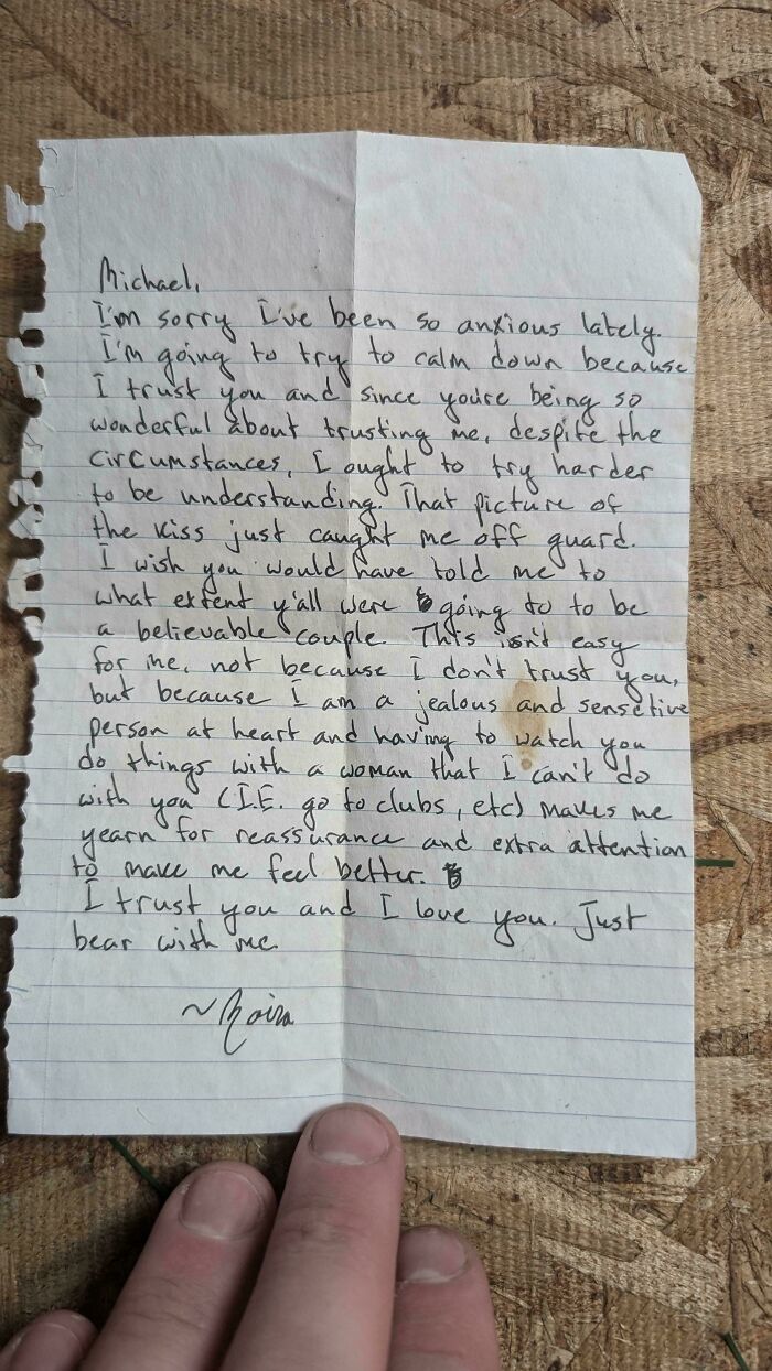 Handwritten historical memento letter expressing trust and emotions, found randomly and photographed on a wooden surface.