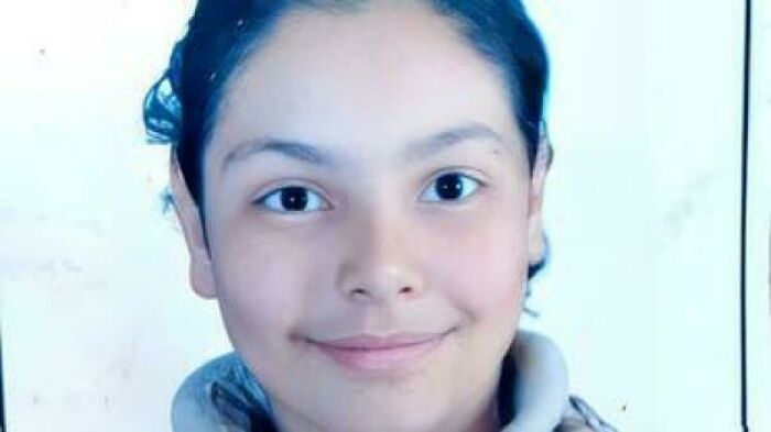 Close-up of a young person with a neutral expression, illustrating themes of traumatizing the next generation.