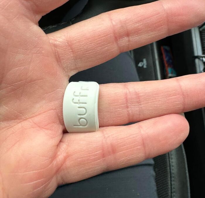 Hand wearing a white finger buffer ring designed for nail care, demonstrating designers understanding hyper specific life issues.