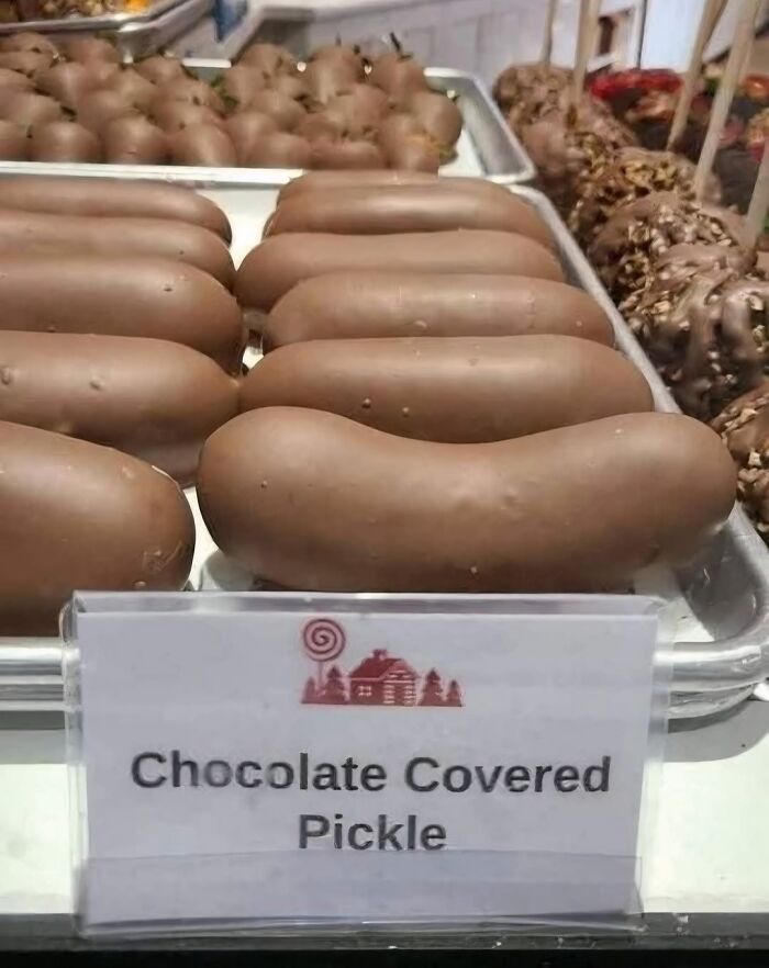 Chocolate covered pickles displayed in rows on a tray, an unusual and gross food choice that might lose your appetite.
