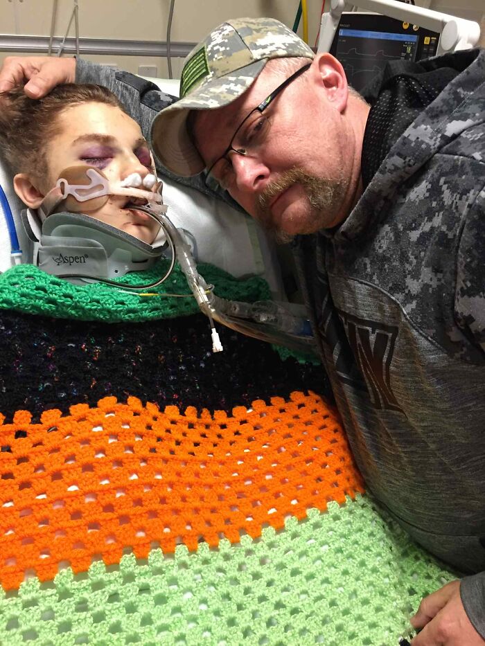 A dad holds his late son's hand in a hospital, capturing a moment before hearing the heartbeat inside a teddy bear.