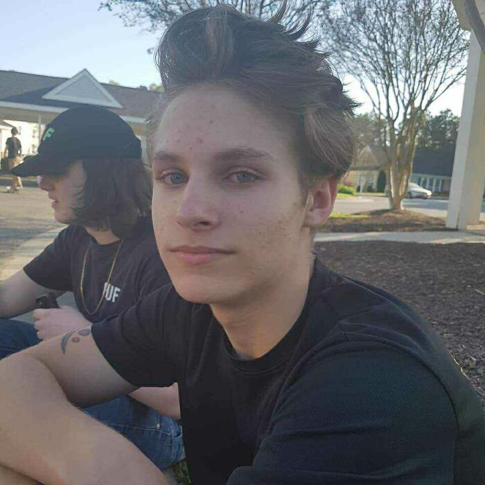 Young man sitting outside with a thoughtful expression, symbolizing connection to a late son&rsquo;s heartbeat in a teddy bear.