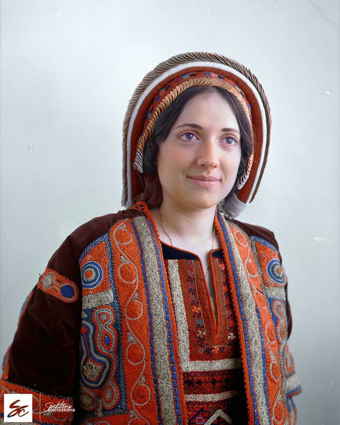 Woman wearing traditional embroidered clothing and headwear in an interesting colorized history pic portrait.