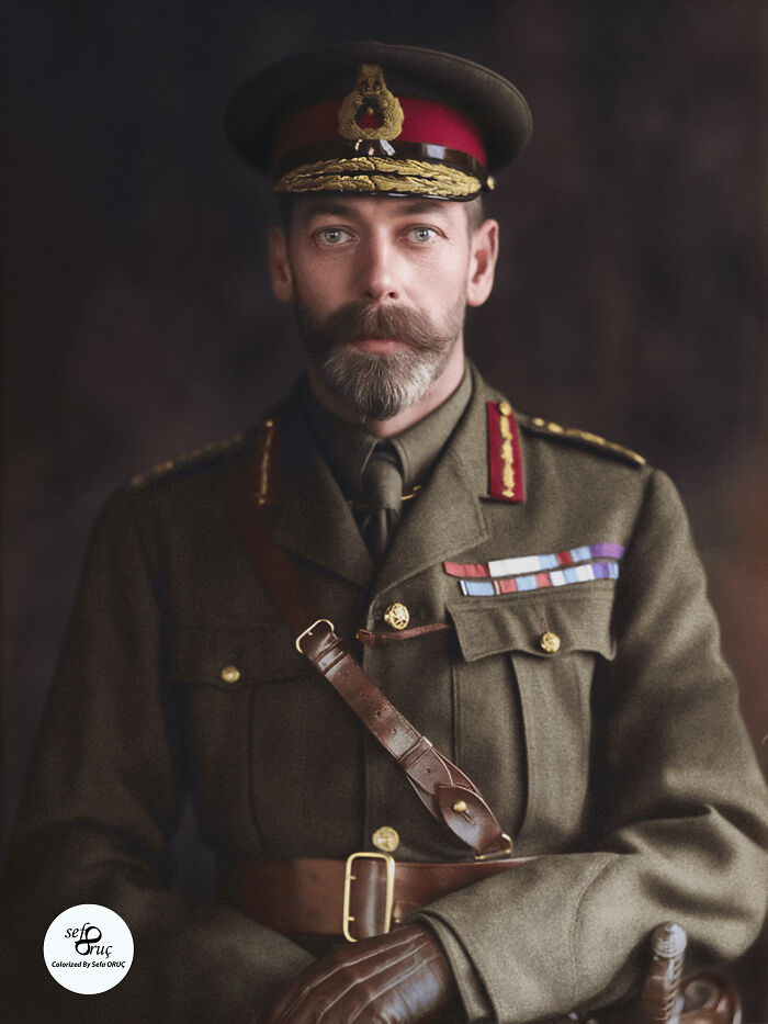 Colorized history pic of a World War I British officer in full military uniform with medals and a leather strap.