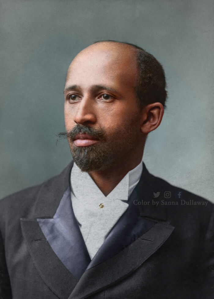 Colorized historical portrait of a man with a beard wearing a dark suit and white shirt in interesting colorized history pics style.