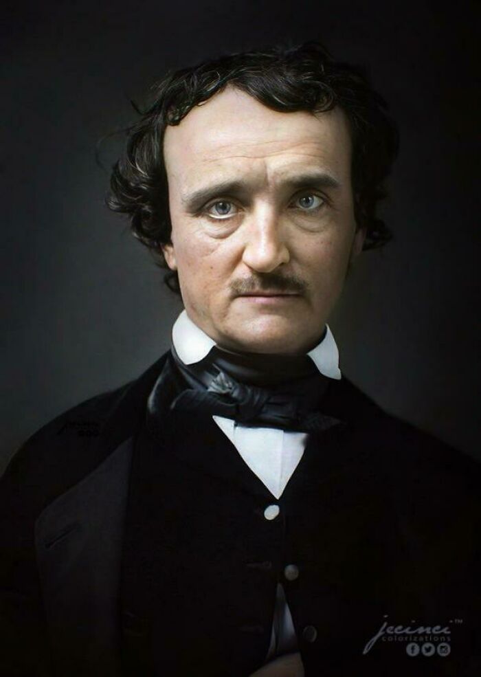 Colorized history pic of Edgar Allan Poe wearing a black formal suit with a serious expression against a dark background.