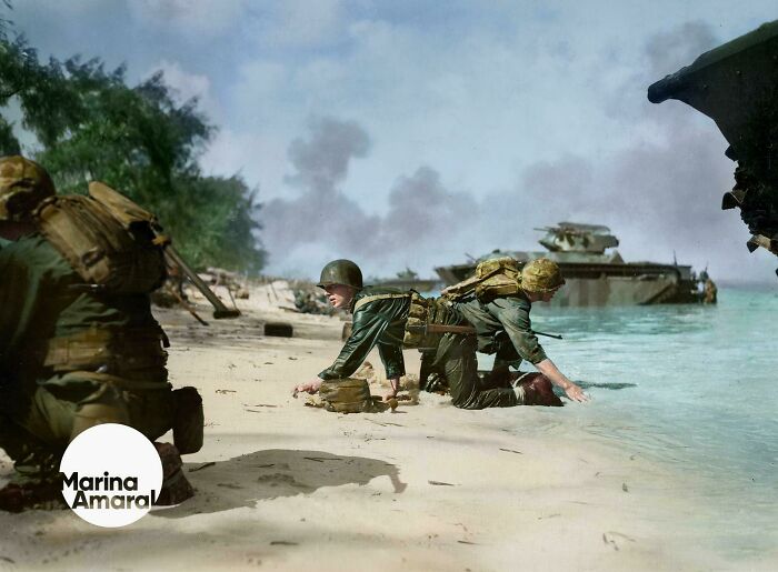 Soldiers landing on a beach during World War II in an interesting colorized history pics scene.