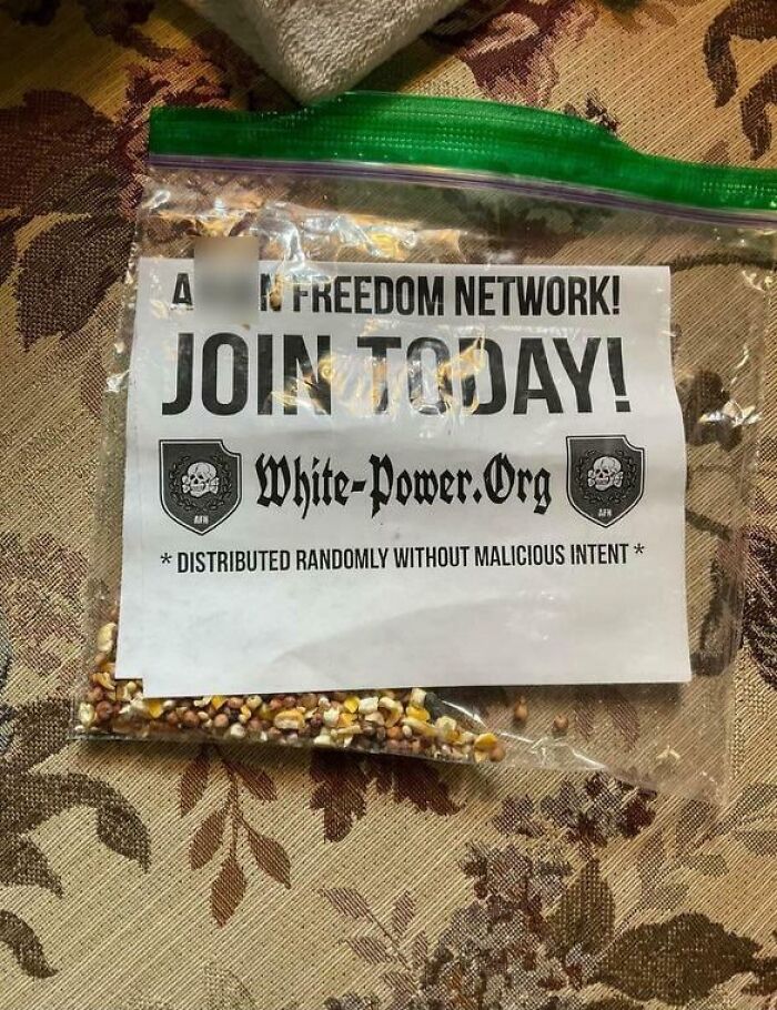 Seed packet with a flyer promoting a hate group, highlighting the theme of traumatizing the next generation with disturbing content.