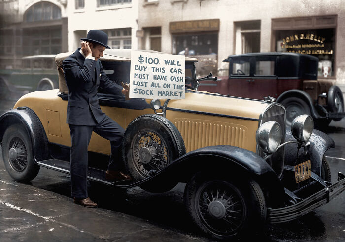 Man in a suit holding a sign to sell a vintage car after losing money on the stock market in interesting colorized history pics.