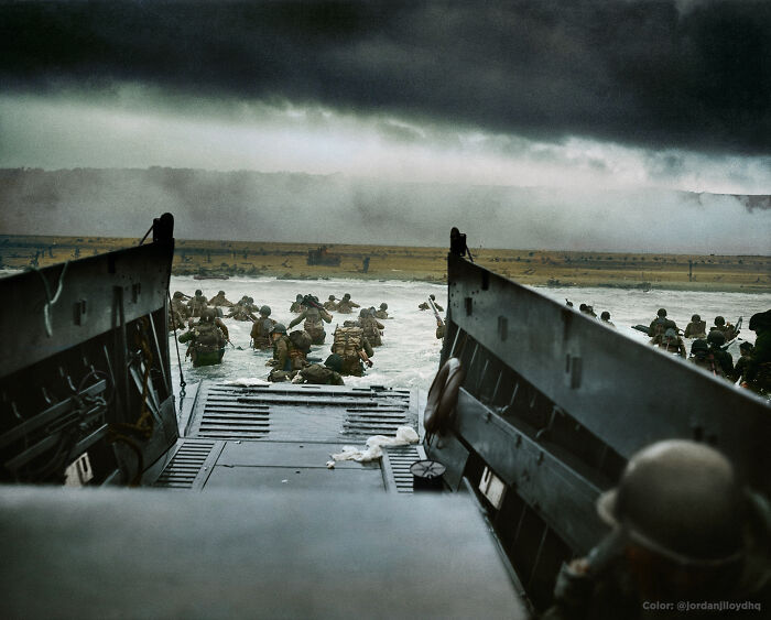 Soldiers wading through water from a landing craft during a historic military invasion in interesting colorized history pics.