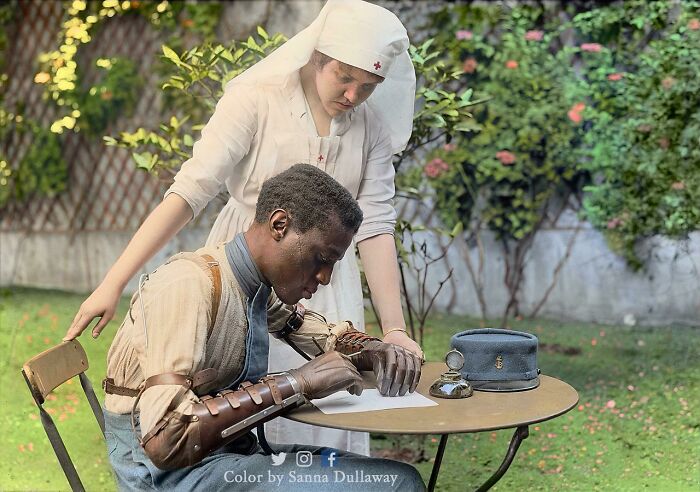 Nurse assisting a wounded soldier with a mechanical arm writing a letter in an interesting colorized history pic.