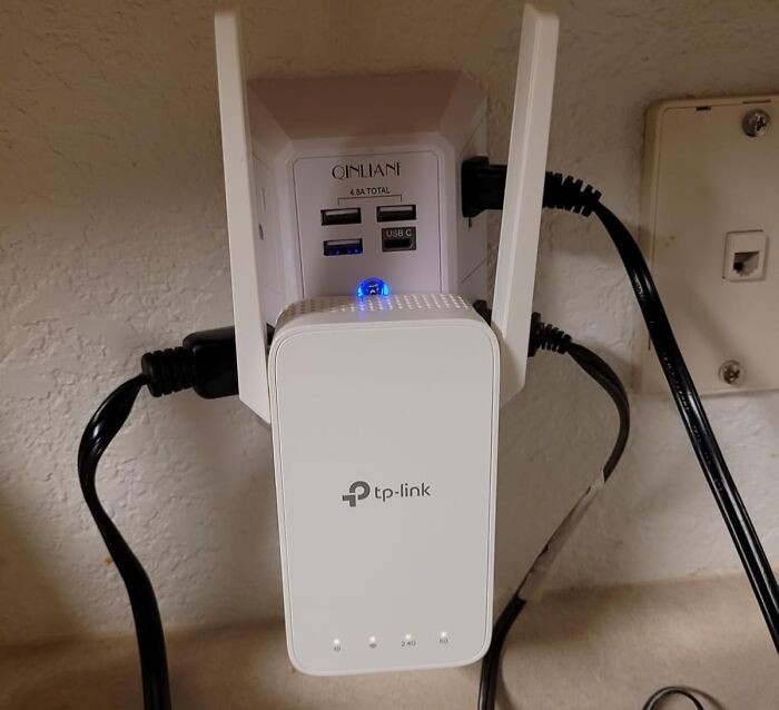 TP-Link device plugged into a USB charger with multiple ports, showcasing modern tech glow up of old inventions.