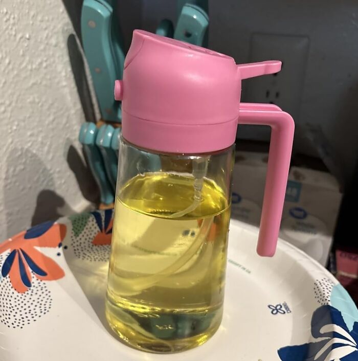 Vintage oil dispenser with a pink lid and handle, showcasing an old invention that got a major glow up.