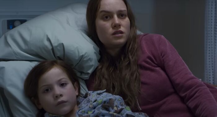A woman and child lying in a hospital bed, depicting an emotional scene from greatest films of the new millennium.