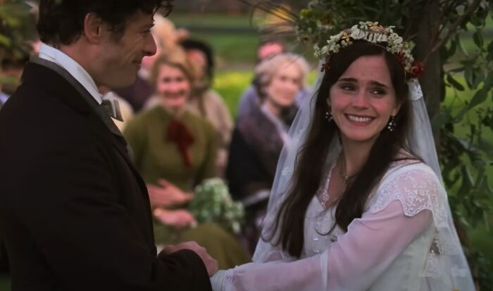 Bride and groom holding hands and smiling during an outdoor wedding scene from the greatest films of the new millennium