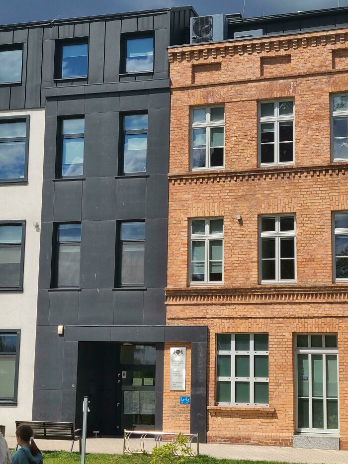 Side-by-side comparison of modern black building facade and traditional brick building showing variety in architecture.