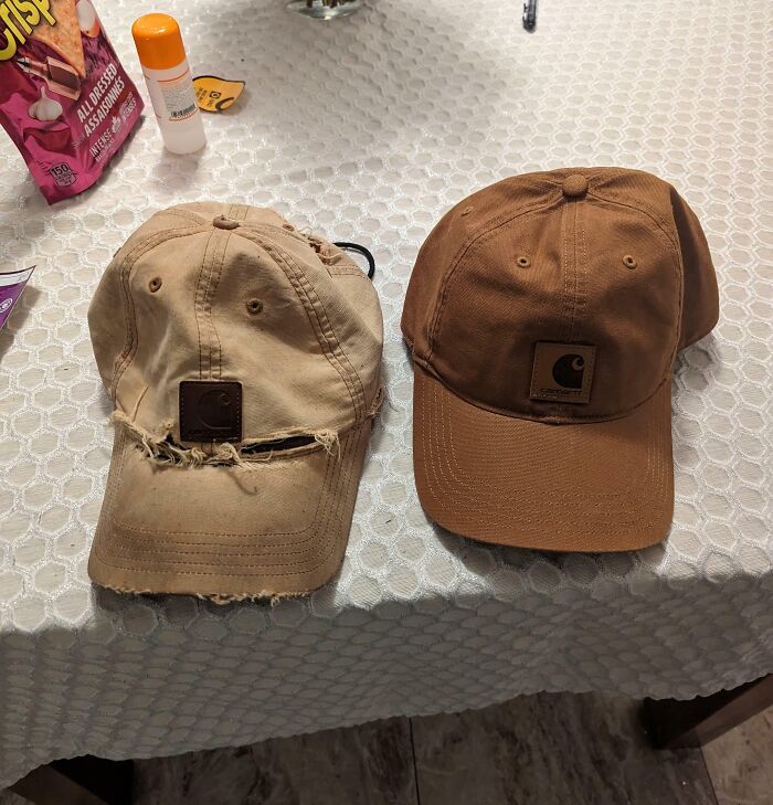 Comparison pic of two Carhartt caps side by side showing variety and wear differences on a textured tablecloth.