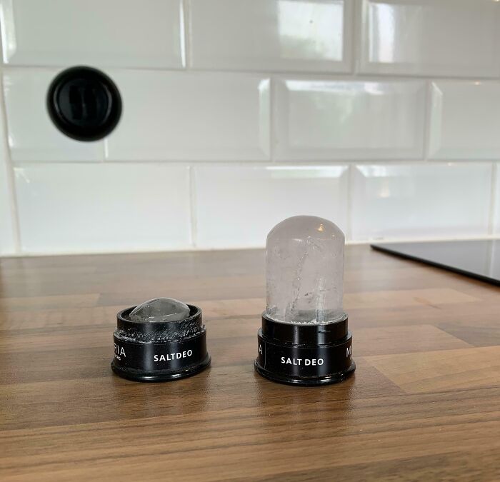 Two salt deo containers on a kitchen counter showing size and shape variety in comparison pics.