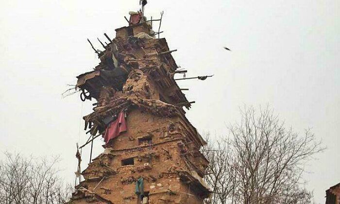 Tall, rustic tower made of wood and mud, showcasing fascinating content and amazing interesting facts about unique architecture.