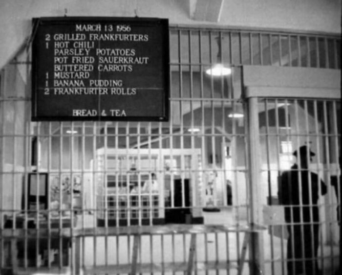 Black and white photo of a prison kitchen area with a meal menu showing fascinating and interesting facts about inmate food.
