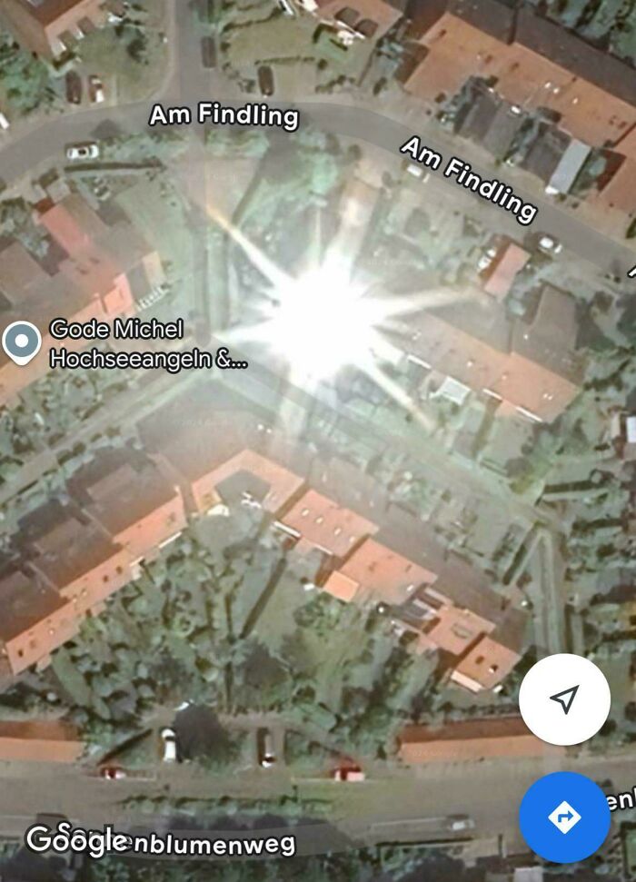 Satellite view of a street with a bright glare anomaly captured on Google Maps showcasing unusual shenanigans.