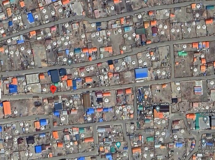 Aerial view of densely packed neighborhood with colorful rooftops showing shenanigans captured on Google Maps.